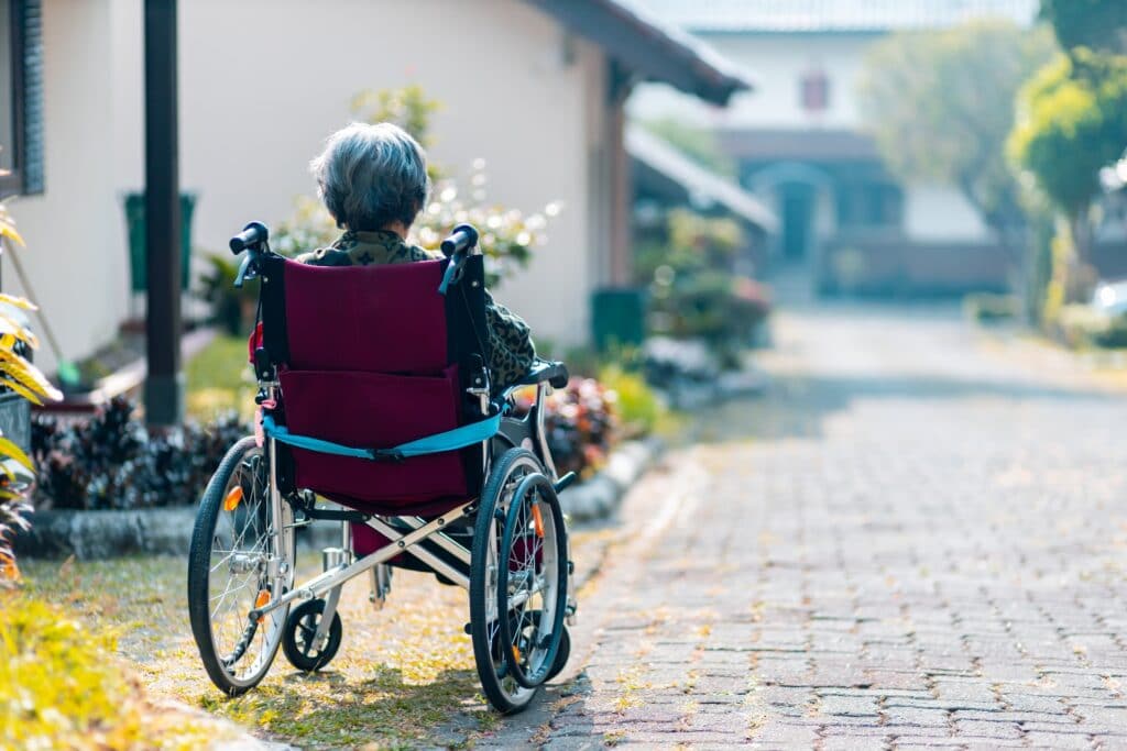 Afbeelding: Vrouw in rolstoel van achteren gefotografeerd
