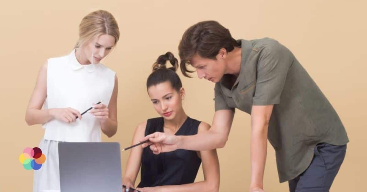 Een marketingteam kijkt gezamenlijk naar een laptop