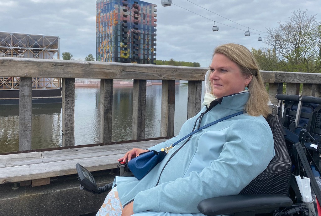 Judith in een blauwe jas en rolstoel op de Floriade 2022