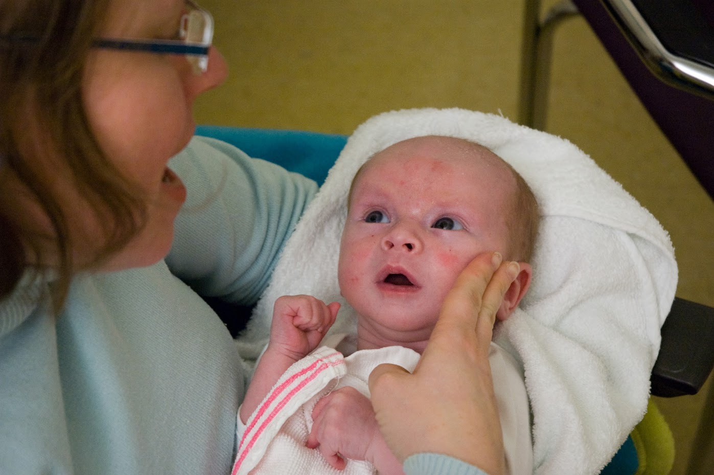 Claire praat tegen baby Florian die in een handdoek gewikkeld in haar armen ligt.