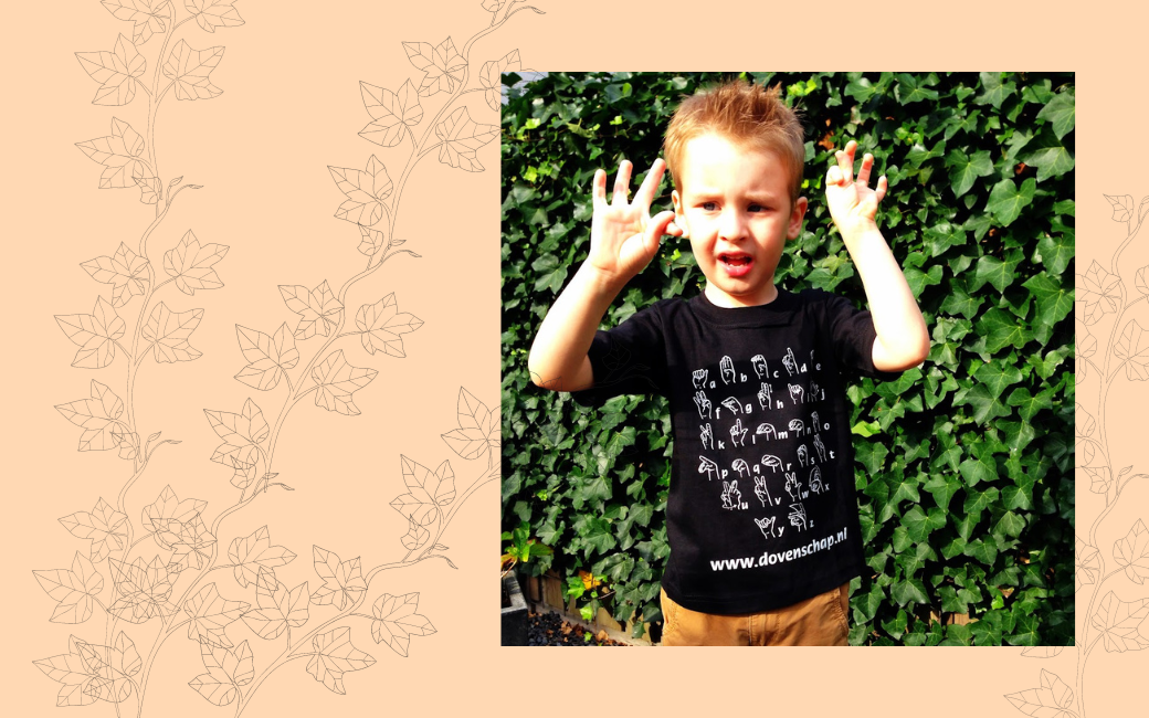 Een nog jonge Florian draagt een t-shirt van Dovenschap en maakt gebaren richting de fotocamera.